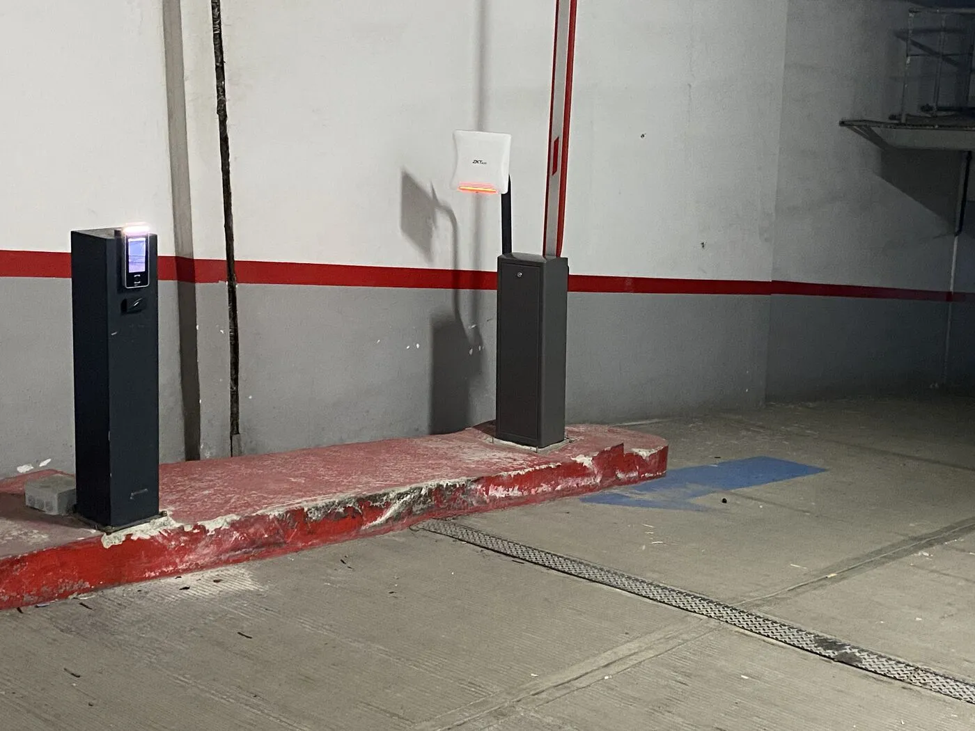 Borne à écran, lecteur UHF ZKTeco et barrière automatique dans un parking souterrain de résidence