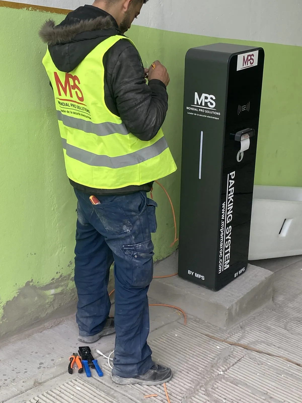 Technicien MPS câblant une borne de parking