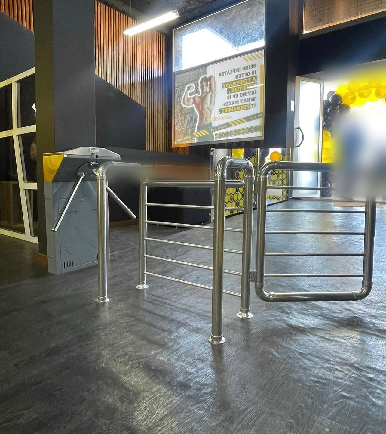 Tourniquet tripode ZKTeco et portillon inox dans une salle de sport